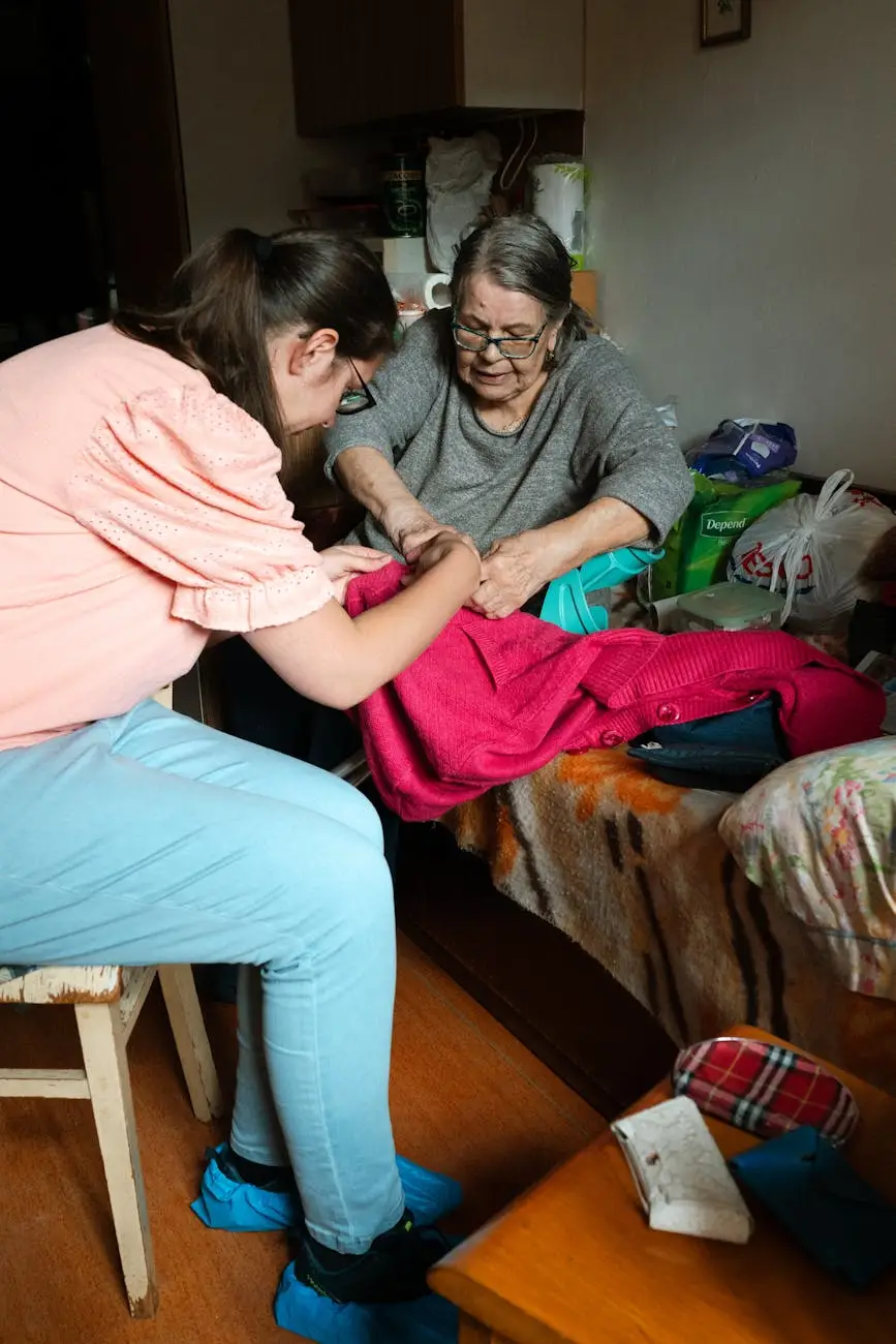 A caregiver helps a senior woman with sewing indoors in Prague.