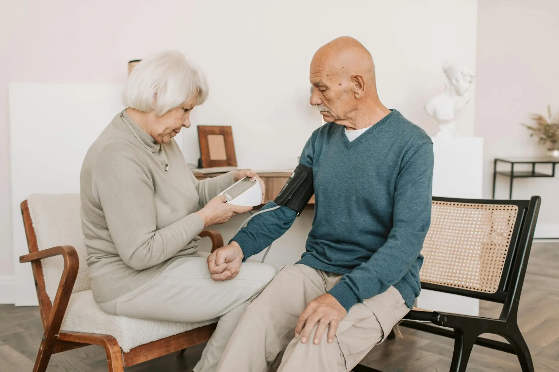 Senior couple at home measuring blood pressure, promoting health monitoring.
