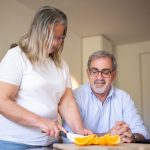 Pflegekraft versorgt sorgfältig eine Wunde am Arm eines Seniors zu Hause – Wundversorgung zu Hause Frankfurt