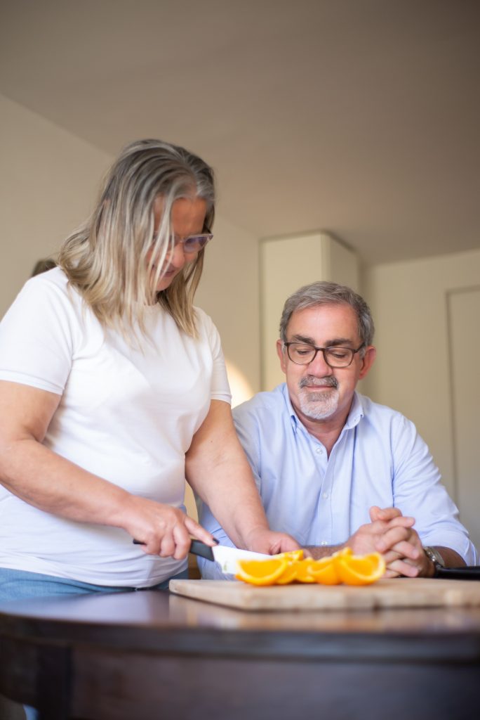 Pflegekraft versorgt sorgfältig eine Wunde am Arm eines Seniors zu Hause – Wundversorgung zu Hause Frankfurt